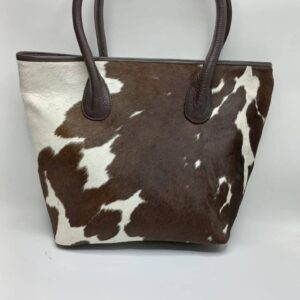 Handmade brown & white cowhide tote purse featuring adjustable shoulder straps.