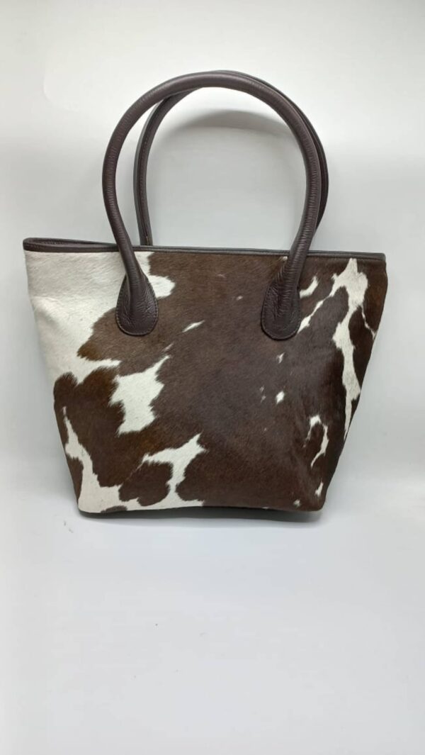 Handmade brown & white cowhide tote purse featuring adjustable shoulder straps.